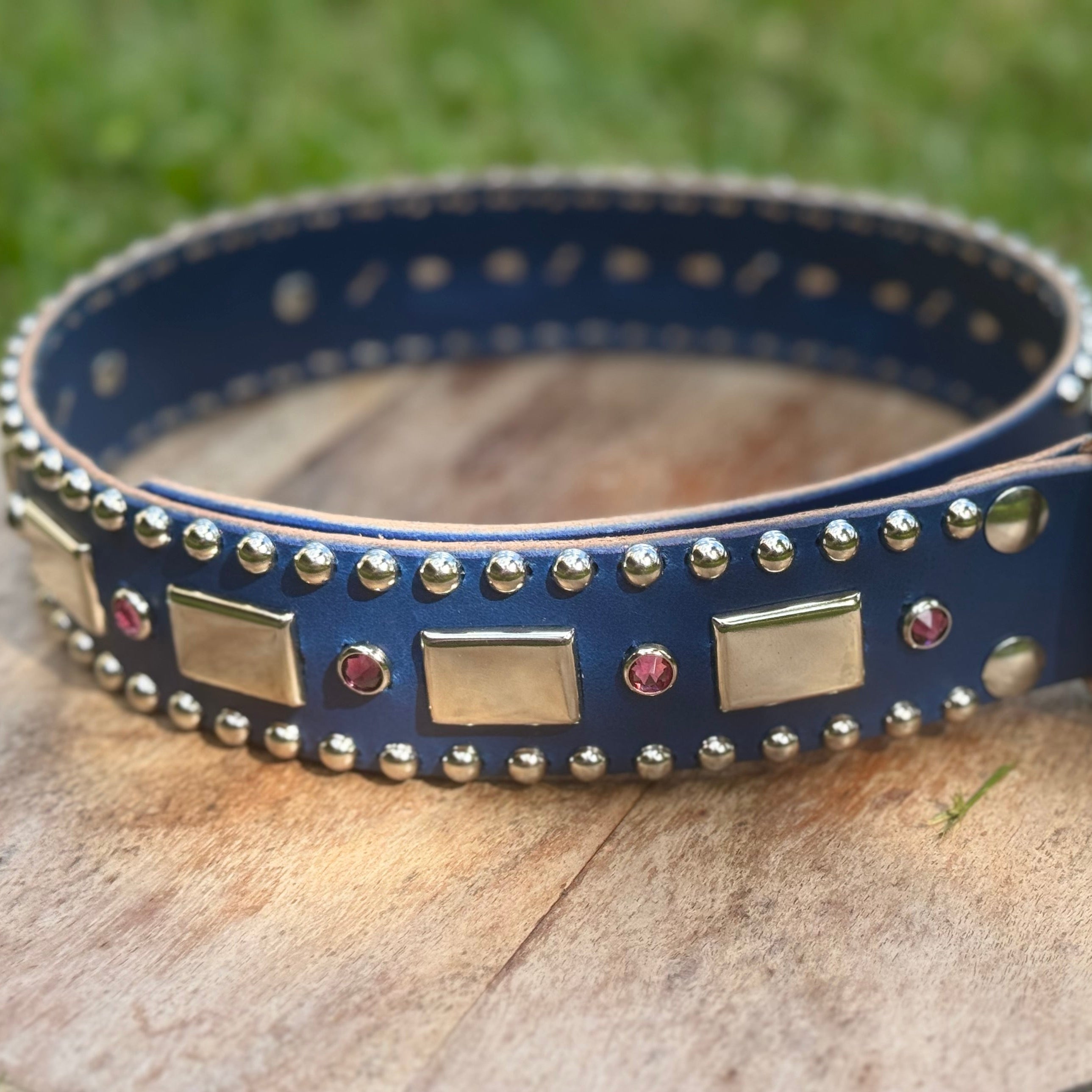 Blue dog collar with decorative studs on a wooden stump
