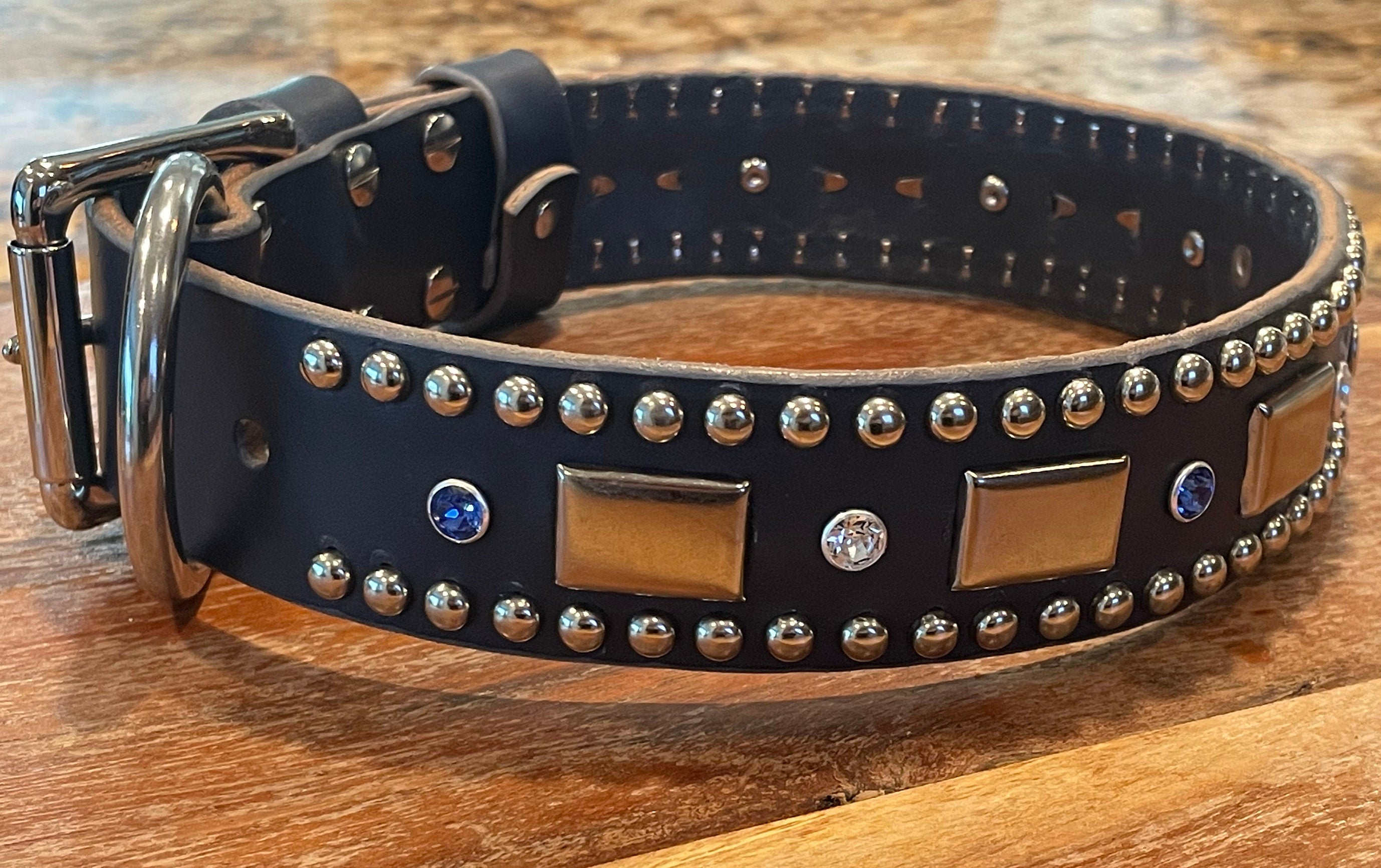 Dog collar with decorative studs and metal accents on a wooden surface